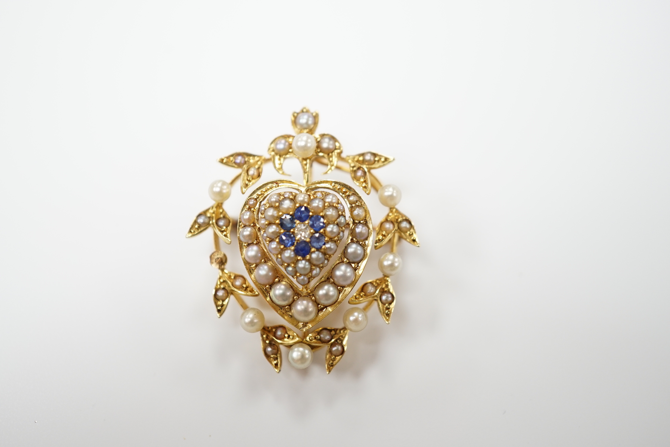 A yellow metal, sapphire, diamond and seed pearl set pendant brooch, with central heart motif, 30mm, gross weight 6.8 grams.